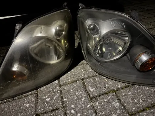 Two headlights side by side, one heavily oxidised and yellowed, the other restored and clear